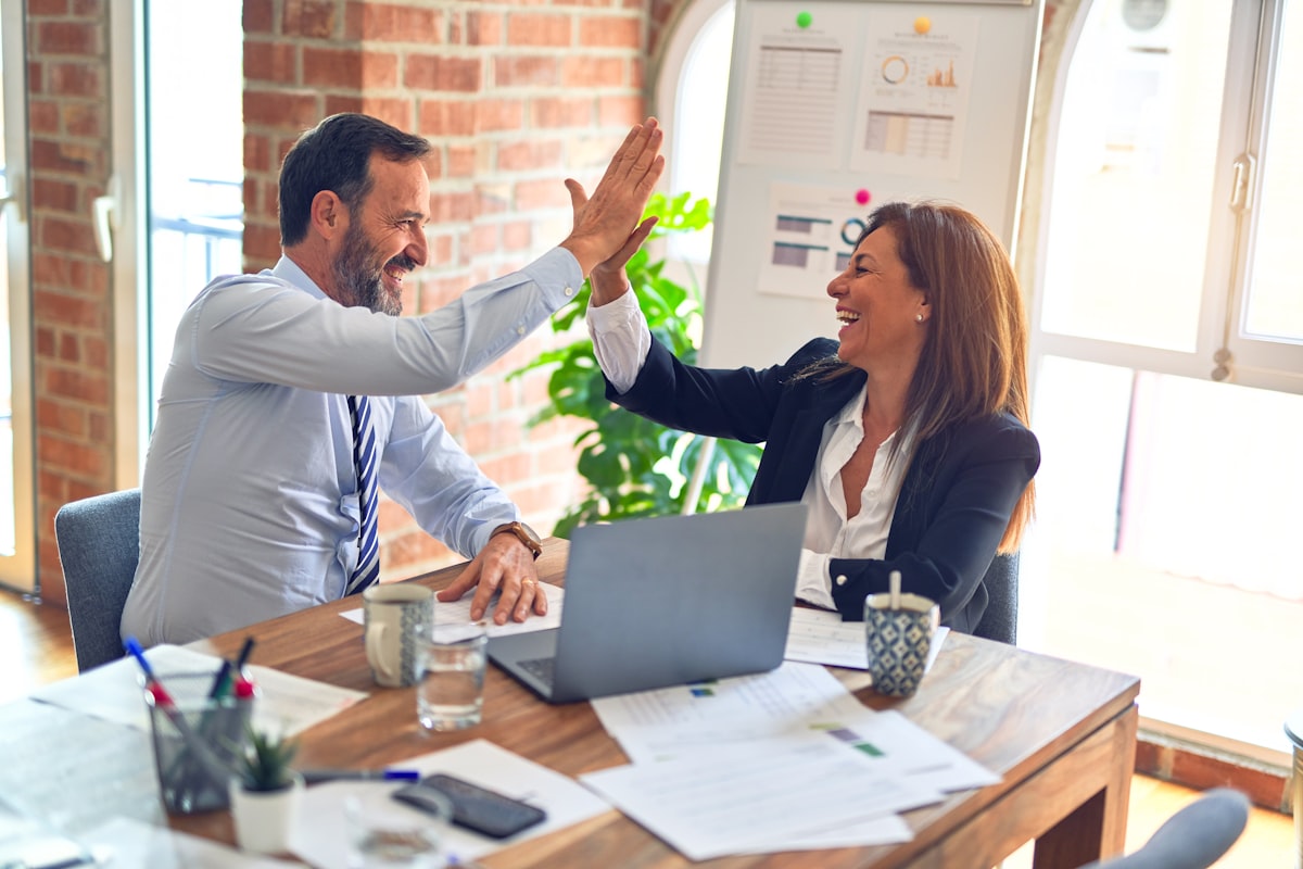 Profissionais de RH comemorando resultados em reunião de trabalho